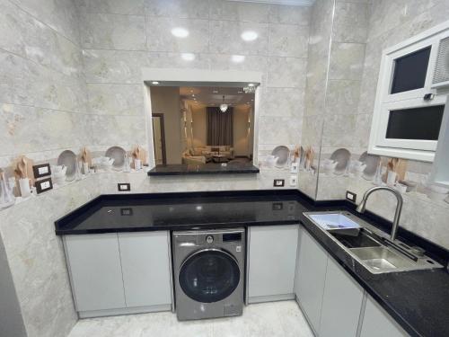 a bathroom with a washing machine and a sink at Grand Luxury Apartments - Downtown Cairo in Cairo