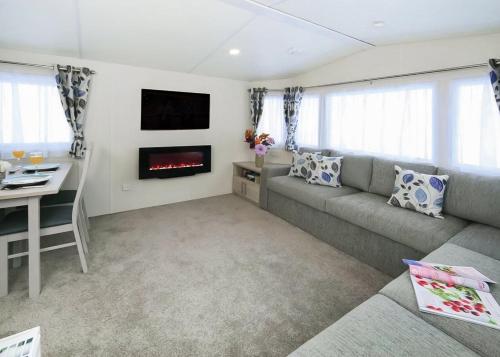 a living room with a couch and a fireplace at Springhouse Country Park in Slaley