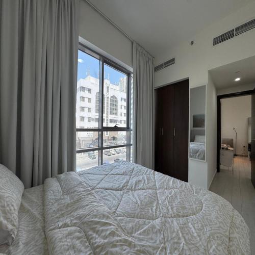a bedroom with a large bed and a large window at Luxury 1-bedroom fully furnished Lifeline apartment in Abu Dhabi