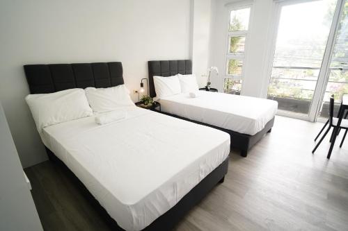a bedroom with two beds and a large window at 20 Boeing Apt in Manila