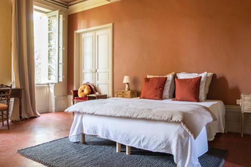 una camera da letto con un grande letto bianco con cuscini rossi di Maison Sumiane a Brignoles