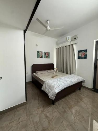 a bedroom with a bed and a ceiling fan at The Cozy Cranny in Chennai
