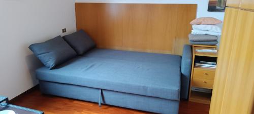 a blue couch in a small room with a table at Appartamento in Garbagnate Milanese