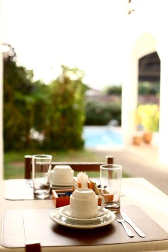 a table with a plate of food and glasses on it at Pousada Recanto da Ladeira in Paraty