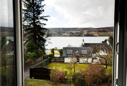 a window with a view of a house and a lake at Chapelhill in Helensburgh