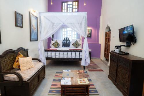 a living room with a bed and a couch at Jafferji House in Zanzibar City