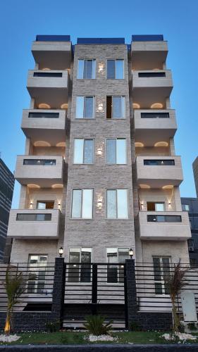 a tall apartment building with a lot of windows at Rivana Residence New Cairo - Pool Access in Cairo