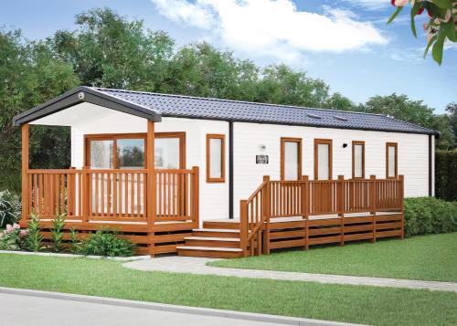 a tiny house with a porch and a deck at Aber Bay Holiday Park in Aberystwyth