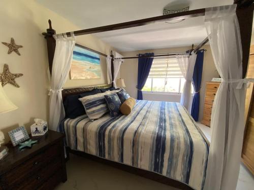 ein Schlafzimmer mit Himmelbett und Fenster in der Unterkunft Aruba Beach Front in Savaneta