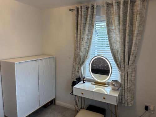 baño con espejo, lavabo y ventana en ADI Holiday Home Lurgan, en Lurgan