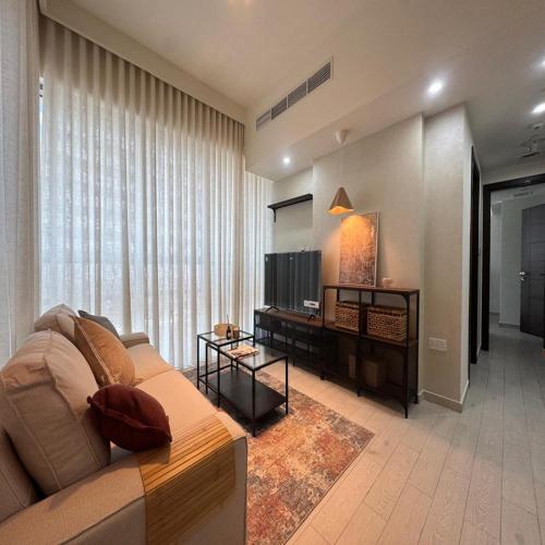 a living room with a couch and a television at Premier 2-bedroom Lifeline apartment with free Parking in Abu Dhabi