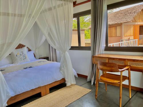 a bedroom with a bed and a desk and a chair at Villas Kokoa Serena in Sainte Marie
