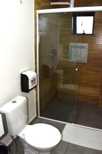 a bathroom with a toilet and a glass shower at Hotel Internacional Guarulhos in Sao Paulo