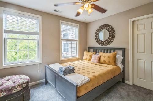 Un dormitorio con una cama y dos ventanas. en South Side Luxury - Walk to Carson Street and Parking, en Pittsburgh
