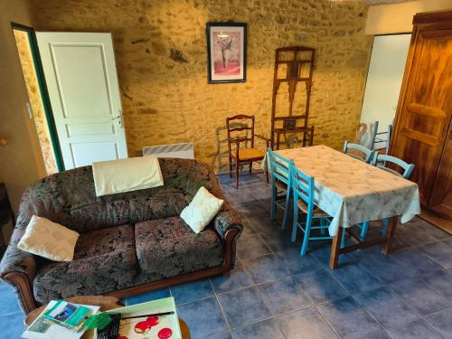 a living room with a couch and a table at Ferme de la Rivière in Montferrand-du-Périgord