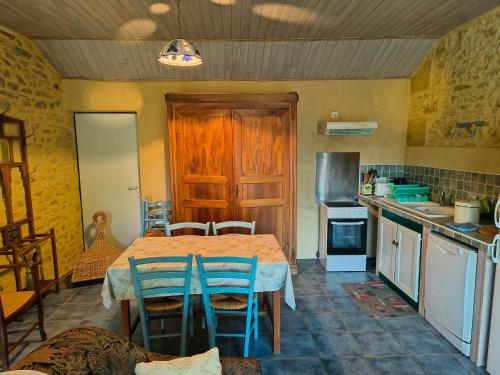 a kitchen with a table and chairs in a room at Ferme de la Rivière in Montferrand-du-Périgord