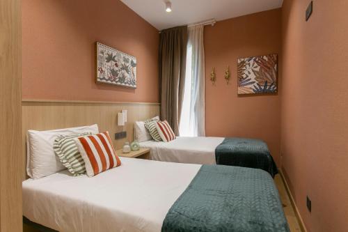 Una habitación de hotel con dos camas y una ventana. en Sagrada Familia Xamfrà, en Barcelona