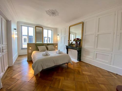 a bedroom with a bed and a large mirror at Gîte Vosges en Ville luxueux appartement Duplex avec sauna espace bien être au centre d'Epinal in Épinal