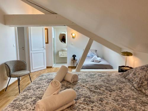 エピナルにあるGîte Vosges en Ville luxueux appartement Duplex avec sauna espace bien être au centre d'Epinalのベッドとタオル2枚のある寝室