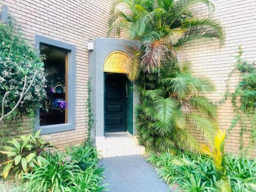 a house with a palm tree in front of a door at Grafiti Boutique Hotel in Bela-Bela