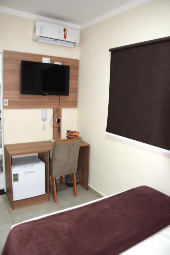 a room with a bed and a desk and a blackboard at Hotel Internacional Guarulhos in Sao Paulo