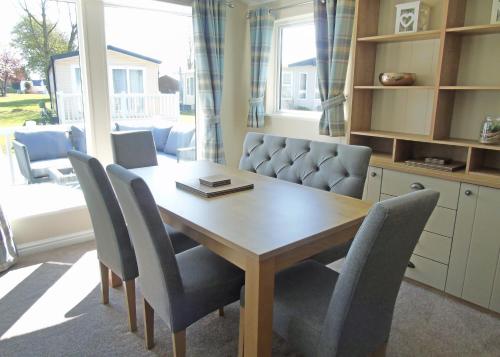 a dining room with a wooden table and chairs at Fir Trees in Chester
