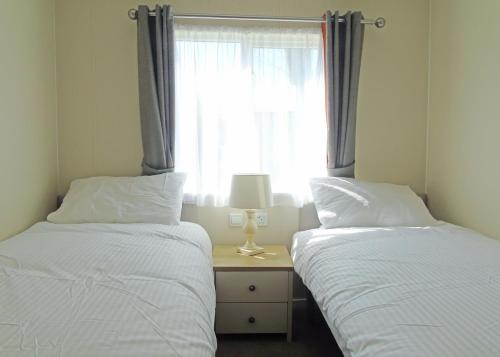 two beds in a room with a window at Fir Trees in Chester