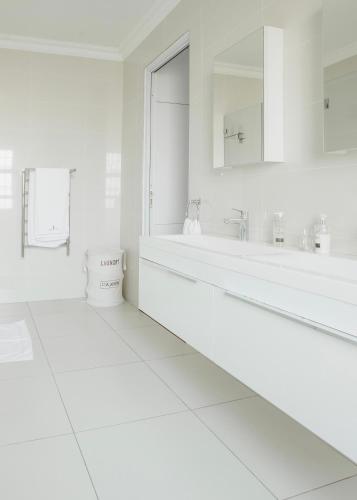 a white bathroom with a tub and a sink at Naledi@53 Private Game Farm in Brits