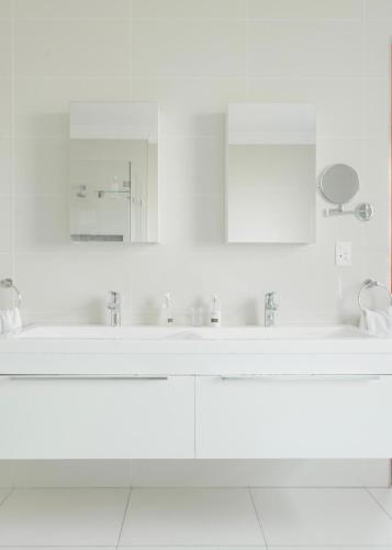 a white bathroom with a sink and a mirror at Naledi@53 Private Game Farm in Brits
