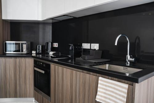 a kitchen with a sink and a microwave at 360 Luxury One Bedroom Suite in Nicosia