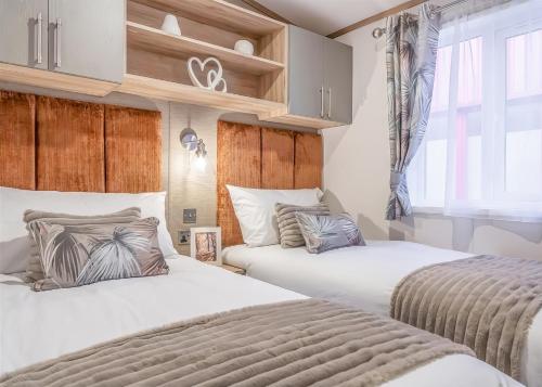a bedroom with two beds and a window at Aber Bay Holiday Park in Aberystwyth
