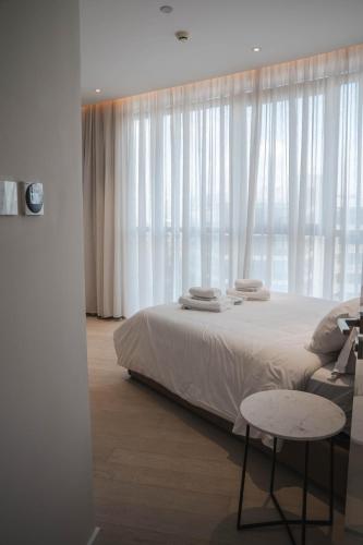 a bedroom with a bed and a window with white curtains at 360 Luxury One Bedroom Suite in Nicosia