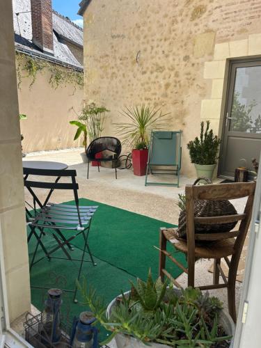 Studio cocooning في فوفري: فناء مع سجادة خضراء وكراسي وطاولة