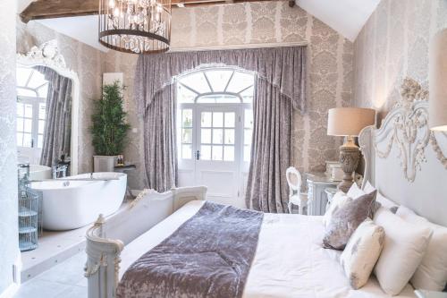 a bedroom with a tub and a bed and a sink at Woodhill Country House in Otterburn