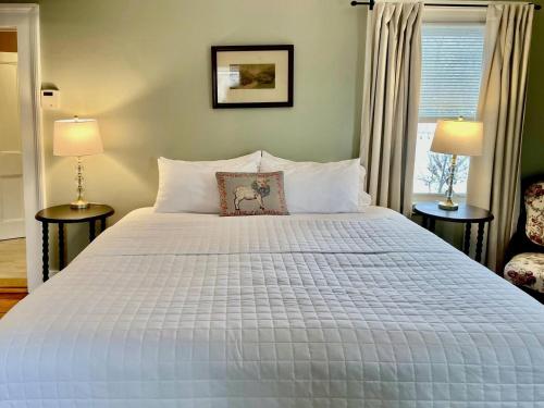 a bedroom with a large white bed with two lamps at Twin Oaks Near Lake Wallenpaupack Historic Home in Hawley