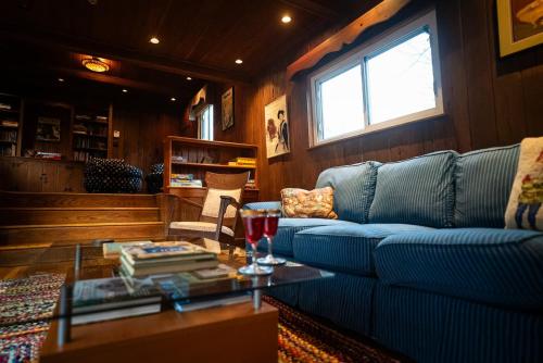 a living room with a blue couch and a table at Twin Oaks Near Lake Wallenpaupack Historic Home in Hawley