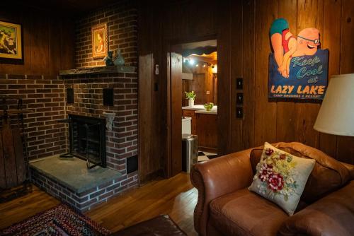 a living room with a couch and a brick fireplace at Twin Oaks Near Lake Wallenpaupack Historic Home in Hawley