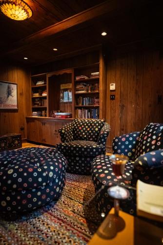 a living room with couches and chairs in a library at Twin Oaks Near Lake Wallenpaupack Historic Home in Hawley