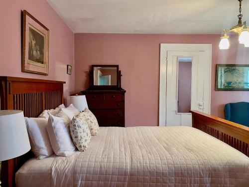 a bedroom with a bed with a dresser and a mirror at Twin Oaks Near Lake Wallenpaupack Historic Home in Hawley
