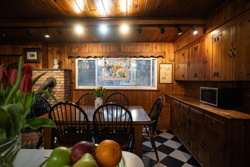 a dining room with a table and chairs and a kitchen at Twin Oaks Near Lake Wallenpaupack Historic Home in Hawley