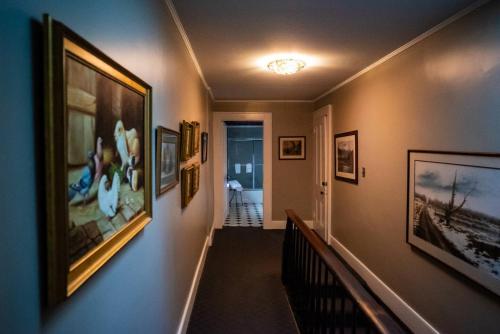 a hallway with pictures on the walls of a house at Twin Oaks Near Lake Wallenpaupack Historic Home in Hawley