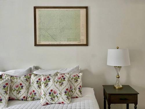 a bed with pillows and a picture on the wall at Twin Oaks Near Lake Wallenpaupack Historic Home in Hawley
