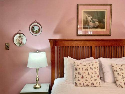 a bedroom with pink walls and a bed with a lamp at Twin Oaks Near Lake Wallenpaupack Historic Home in Hawley