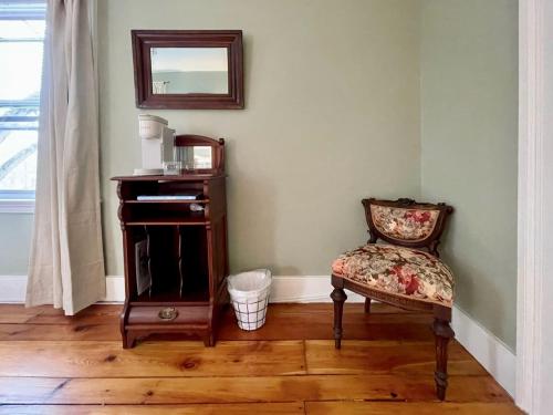 a room with a chair and a mirror on the wall at Twin Oaks Near Lake Wallenpaupack Historic Home in Hawley