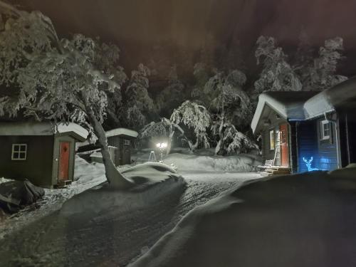 una casa cubierta de nieve por la noche con luz en Mysig liten stuga i Messlingen, en Messlingen