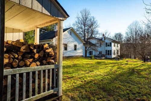 a pile of logs on the side of a house at Twin Oaks Near Lake Wallenpaupack Historic Home in Hawley