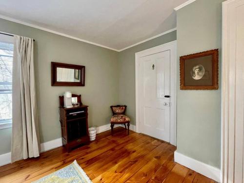 an empty living room with a chair and a window at Twin Oaks Near Lake Wallenpaupack Historic Home in Hawley