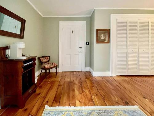a living room with wooden floors and a white door at Twin Oaks Near Lake Wallenpaupack Historic Home in Hawley