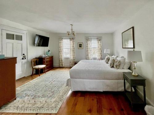 a bedroom with a large white bed and a television at Twin Oaks Near Lake Wallenpaupack Historic Home in Hawley