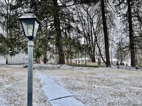 a street light on a sidewalk in a park at Twin Oaks Near Lake Wallenpaupack Historic Home in Hawley